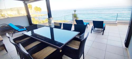 a table and chairs on a balcony with the ocean at Casa do Mar - Luxurious Villa with Swim Spa & sea view in Luz
