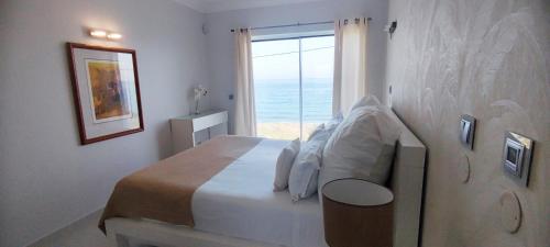 a bedroom with a bed with a view of the ocean at Casa do Mar - Luxurious Villa with Swim Spa & sea view in Luz