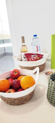 two baskets of apples and oranges on a counter at Casa do Mar - Luxurious Villa with Swim Spa & sea view in Luz