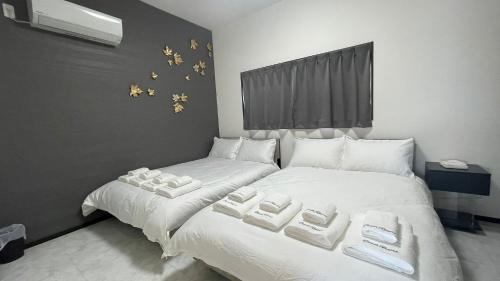 Mare House - Vacation STAY 69168v في Yaka: غرفة نوم بها سريران بملاءات بيضاء ونجوم ذهبية على الحائط