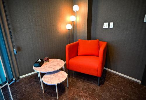 an orange chair and two tables in a room at 8Room - Vacation STAY 70870v in Yachimata
