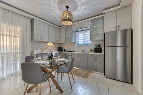 eine Küche mit Tisch und Stühlen und einem Kühlschrank in der Unterkunft Vanesa Villa Retreat, 3BR with Lush Outdoor Oasis by Villa Mana Gers in Romírion