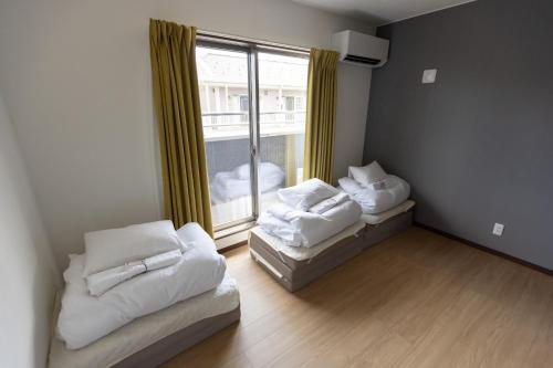 a room with two beds and a large window at Guesthouse Ogaki Kokone C, D - Vacation STAY 72653v in Ogaki