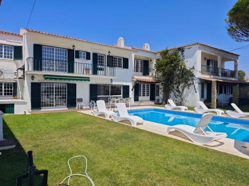 a villa with a swimming pool and a yard at Solar das Mimosas 2 casas in Sintra