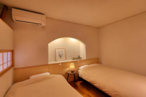 two beds in a room with a mirror and a window at Kazekuru - Vacation STAY 18924 in Fujiyoshida