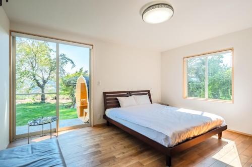 sypialnia z łóżkiem i dużym oknem w obiekcie Casa Verde - Vacation STAY 75624v w mieście Ito