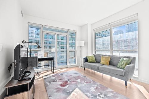 a living room with a couch and a piano at Modern New 2Bd 2Ba &Den Condo with Balcony in Toronto