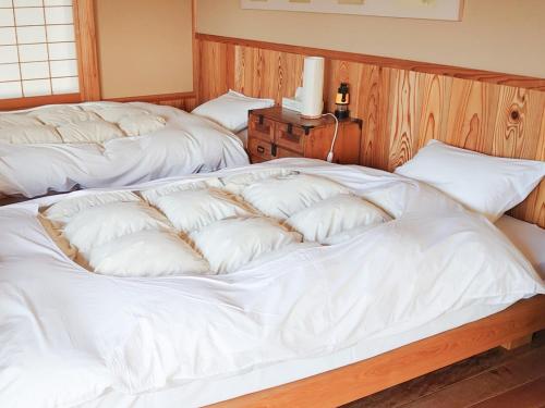 two beds in a room with white sheets at Hida Town House Grass - Vacation STAY 77084v in Takayama