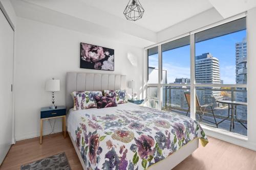 a bedroom with a bed and a large window at Modern New 2Bd 2Ba &Den Condo with Balcony in Toronto