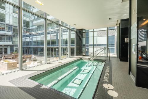 a large swimming pool in a building with windows at Modern New 2Bd 2Ba &Den Condo with Balcony in Toronto
