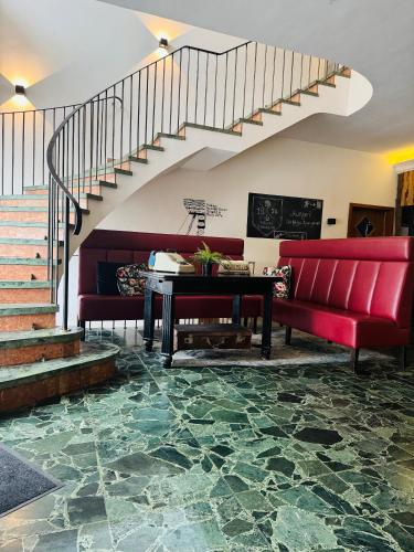 a living room with a red couch and a table at Hotel Sittardsberg in Duisburg