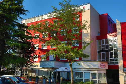 a hotel building with a tree in front of it at Hotel Sittardsberg in Duisburg