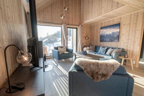 Una sala de estar con un sofá y un televisor. en Cabin at Norefjell ski resort, nice view, en Noresund