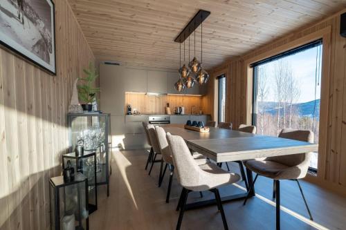 Una cocina y un comedor con mesa y sillas. en Cabin at Norefjell ski resort, nice view, en Noresund
