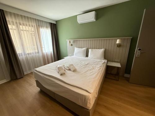 a bedroom with a bed with two slippers on it at OTTO X Hotel in Kavaklıdere