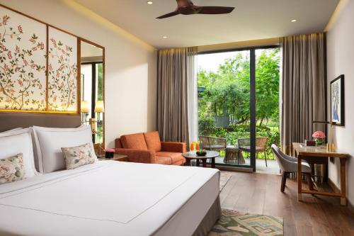 a bedroom with a bed and a living room at Taj Damdama Lake Resort & Spa, Gurugram in Gurgaon