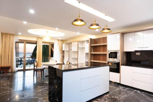 a kitchen with white cabinets and a black counter top at Treetop by Eight Continents, Zanzibar in Mchangani