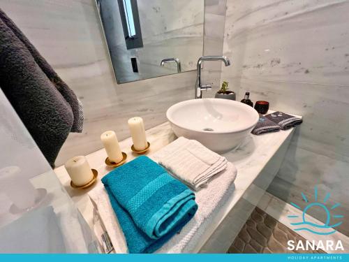 Un baño con un lavabo blanco y un lavabo blanco. en Elysia Park Sanara Holiday Apartments, en Pafos