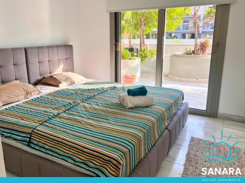 Una cama con un animal de peluche encima. en Elysia Park Sanara Holiday Apartments, en Pafos
