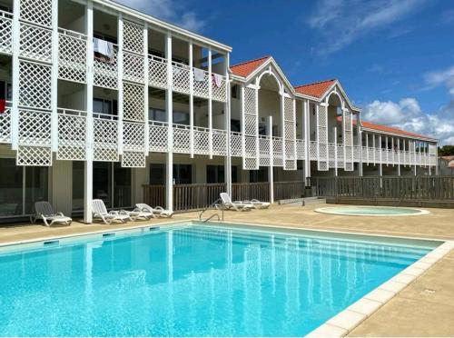 a swimming pool in front of a building at Mimizan plage Balcon des pêcheurs in Mimizan-Plage