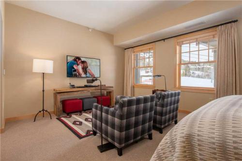 a bedroom with two chairs and a tv on the wall at RMR: Cody House B Condo in Teton Village in Teton Village