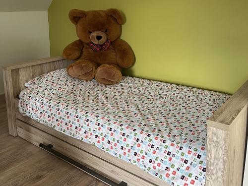 a teddy bear sitting on top of a bed at Holiday Home in Koekelare with Scenic Views in Koekelare