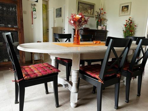 a dining room table with chairs and a vase with flowers at Holiday Home in Koekelare with Scenic Views in Koekelare