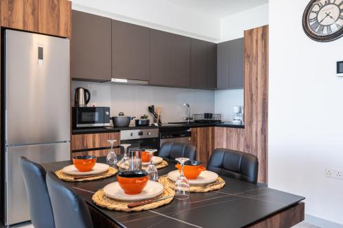 a kitchen with a black table with chairs and a refrigerator at Doria 2-Bedroom Apartment & Balcony in Larnaca in Aradhippou