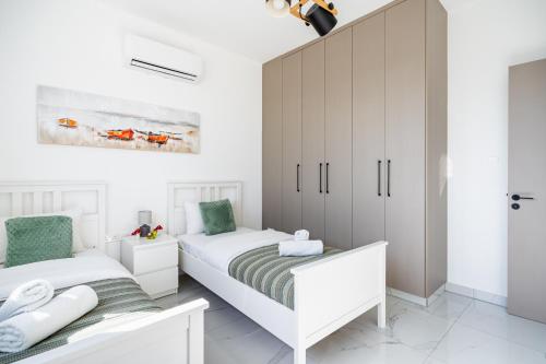 two beds in a bedroom with white cabinets at Doria 2-Bedroom Apartment & Balcony in Larnaca in Aradhippou