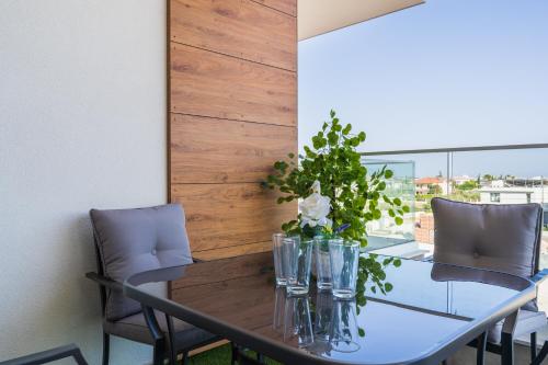 a dining room table with two chairs and a table with flowers on it at Doria 2-Bedroom Apartment & Balcony in Larnaca in Aradhippou