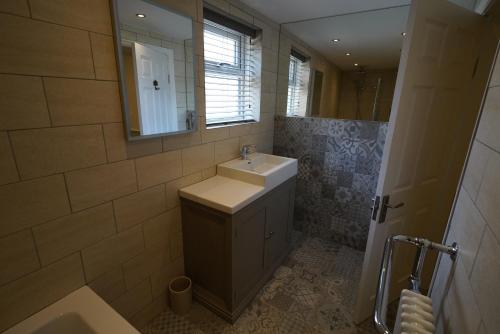 a bathroom with a sink and a mirror at Ruby Sands in Saltburn-by-the-Sea