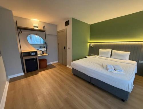 a bedroom with a white bed with a green wall at OTTO X Hotel in Kavaklıdere