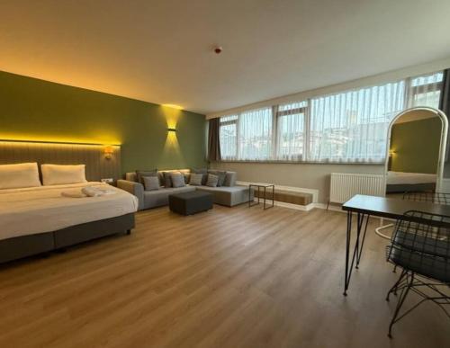 a bedroom with a bed and a couch and a table at OTTO X Hotel in Kavaklıdere