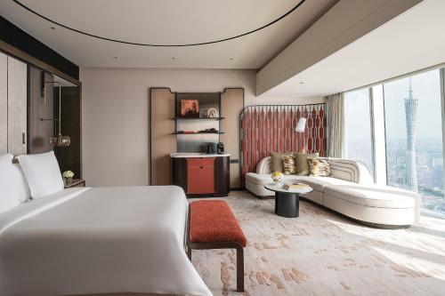 a hotel room with a bed and a couch at Four Seasons Hotel Guangzhou - Free Shuttle Bus to Canton Fair Complex & Overseas Buyer Registration Services during Canton Fair Period in Guangzhou