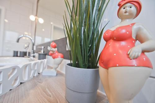 a figurine of a woman in a pot next to a plant at Deichhöhe 7 HU in Norddeich
