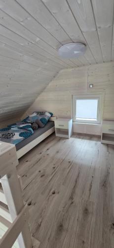 a bedroom with a bed and a window in a attic at Biały Sztorm in Rusinowo