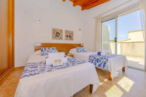 a bedroom with two beds with blue and white sheets at Villa Synera in Alcudia