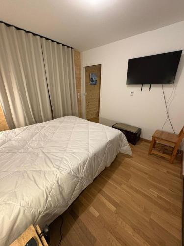 a bedroom with a bed and a flat screen tv at Vars Livingstone in Vars