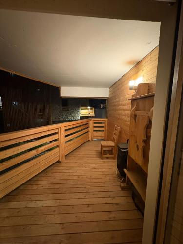 a balcony with a wooden floor and a wooden chair at Vars Livingstone in Vars