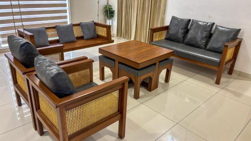 a living room with chairs and tables and a couch at Thulasi Avenue Inn in Pollāchi