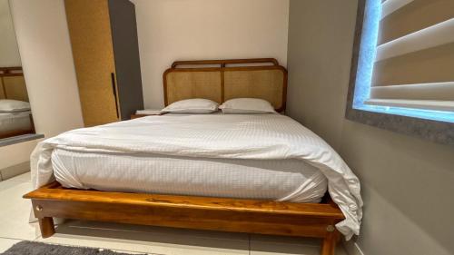 a bedroom with a bed with a wooden frame and a window at Thulasi Avenue Inn in Pollāchi