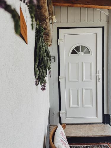 a white door with a plant next to it at Ferienwohnung Leonhardbauer in Kleinfeistritz