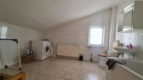 a bathroom with a sink and a washing machine at Ferienwohnung Blumenberg Gänsefurther Str in Staßfurt