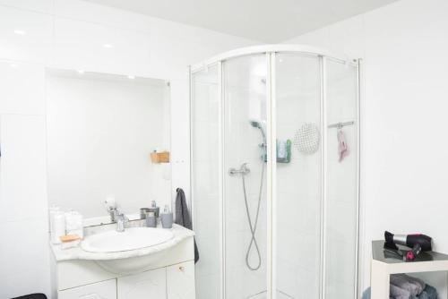 a white bathroom with a shower and a sink at Kaze - Bienvenue chez vous in Grimbergen