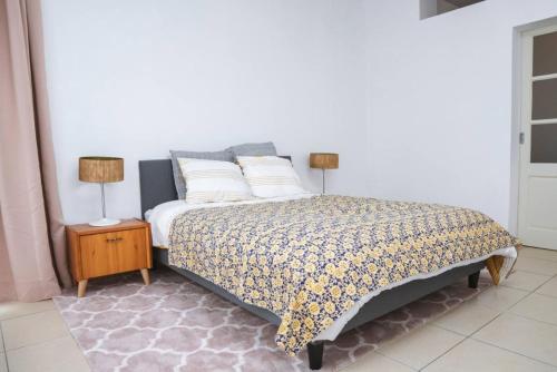 a bedroom with a bed with two lamps on a night stand at Kaze - Bienvenue chez vous in Grimbergen