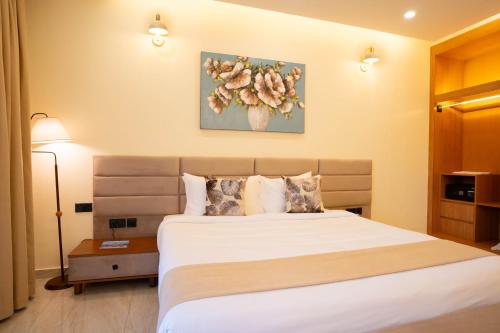 a bedroom with a bed and a painting on the wall at Treetop by Eight Continents, Zanzibar in Mchangani