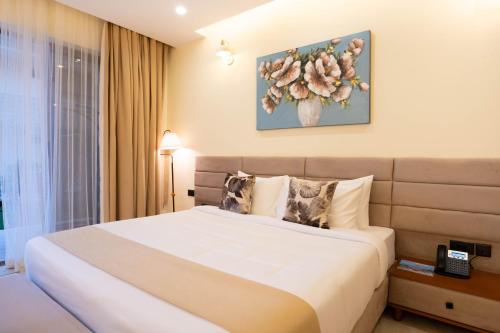 a hotel room with a bed and a flower painting on the wall at Treetop by Eight Continents, Zanzibar in Mchangani