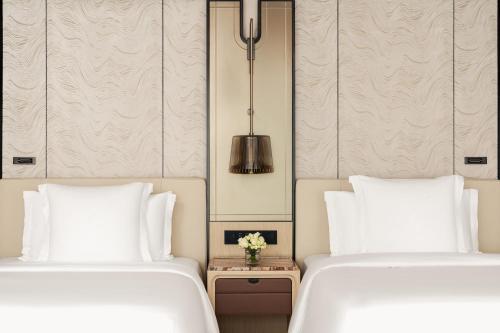 two beds sitting next to each other in a bedroom at Four Seasons Hotel Guangzhou - Free Shuttle Bus to Canton Fair Complex & Overseas Buyer Registration Services during Canton Fair Period in Guangzhou