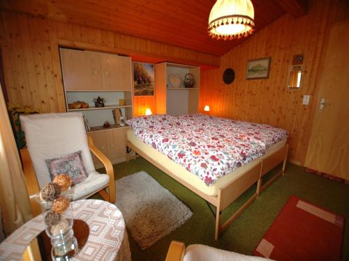 a bedroom with a bed and a chair in it at Chalet in Wilderswil with Jungfrau Views in Wilderswil