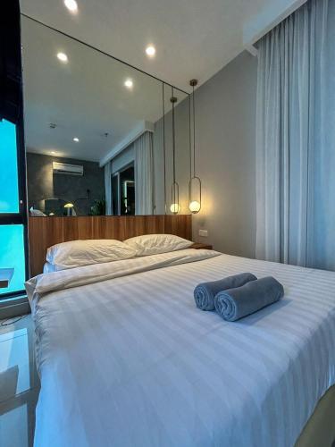a large white bed with two blue towels on it at The Shore Kota Kinabalu City Centre by LW Suites in Kota Kinabalu